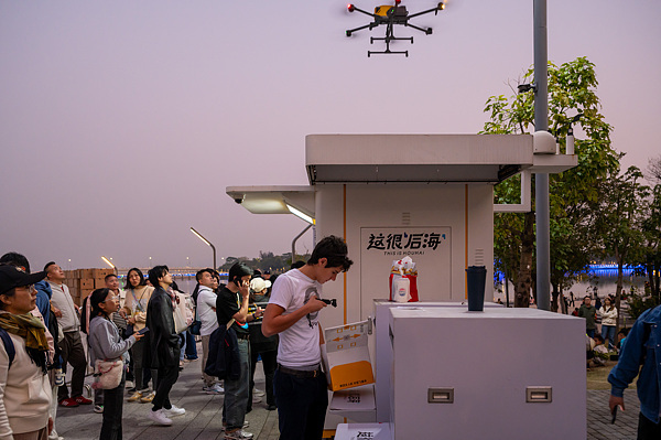 在深圳，外國(guó)游客體驗(yàn)無(wú)人機(jī)外賣(mài)送餐。