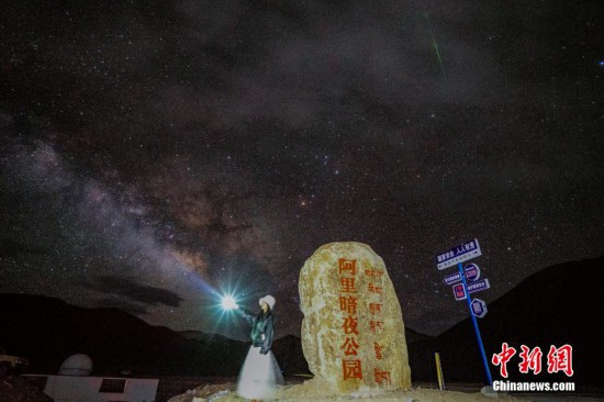 圖為6月20日晚，游客“打卡”西藏阿里暗夜公園，天上是銀河與流星（右上角）。曹枝清 攝