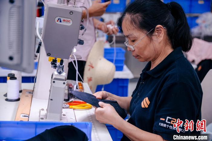 圖為員工在生產(chǎn)線工作?！±钅宪?攝