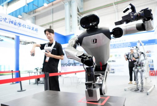 9月5日，在沈陽的2025全球工業(yè)互聯(lián)網(wǎng)大會的展覽區(qū)現(xiàn)場，中國科學(xué)院沈陽自動化研究所的機器人工程師在調(diào)試具身智能操作系統(tǒng)。新華社記者 李鋼 攝